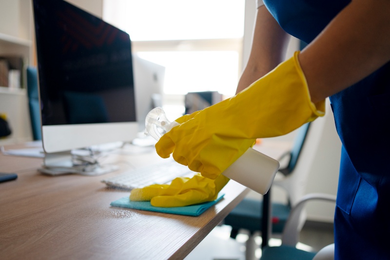 Profesional limpiando correctamente la mesa de una oficina