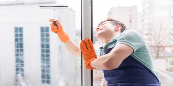 Profesional limpiando los cristales de un edificio con limpiacristales