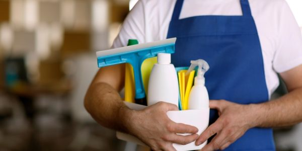 Profesional con productos para la limpieza de un negocio