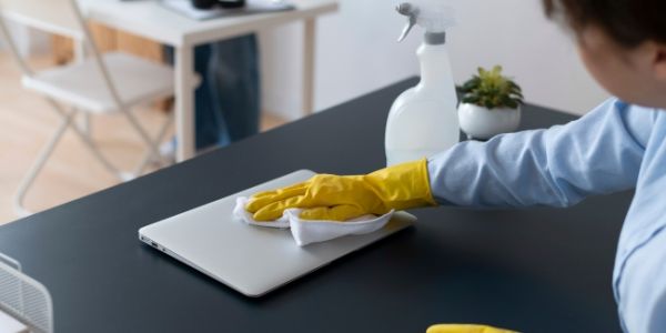 Profesional limpiando y ordenando un puesto de trabajo en una oficina